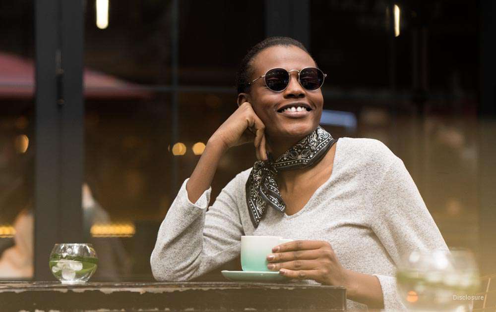 A woman drinking coffee wearing transition glasses
