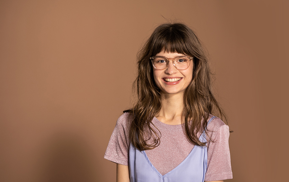 Woman with long brown hair and transparent glasses