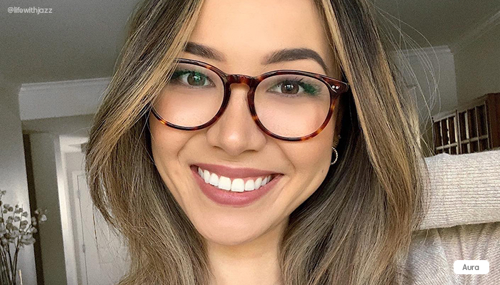 A woman wearing round tortoiseshell-colored eyeglasses