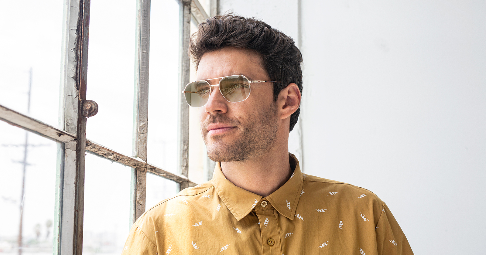 A man in front of a window wearing transition glasses