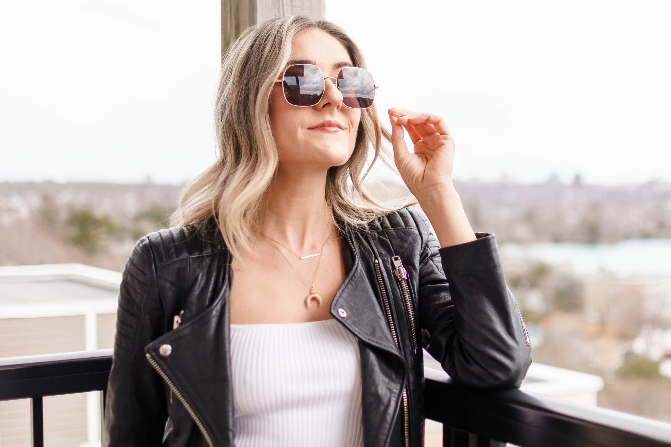 A woman on a balcony wearing square transition glasses