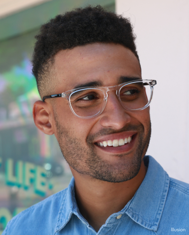 A smiling man wearing clear-frame eyeglasses