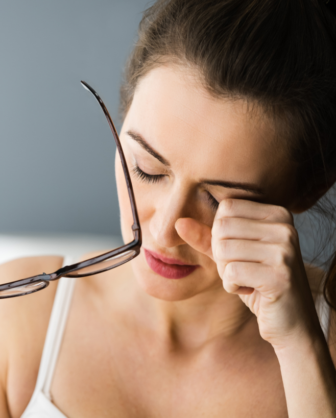 A woman rubbing her eyes due to eye strain